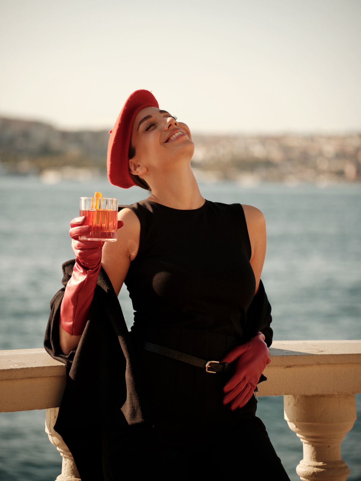 Boğaz kıyısı — kırmızı bereli ve kırmızı eldivenli kadın, kahkaha kadrajı · Doruk Uğurluer.